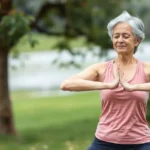 Mulher madura feliz praticando yoga ao ar livre.