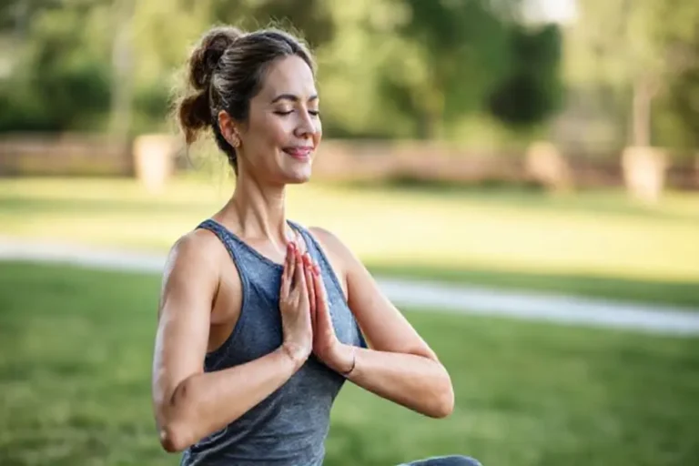 Mulher fazendo yoga em um ambiente natural, representando bem-estar e autocuidado.