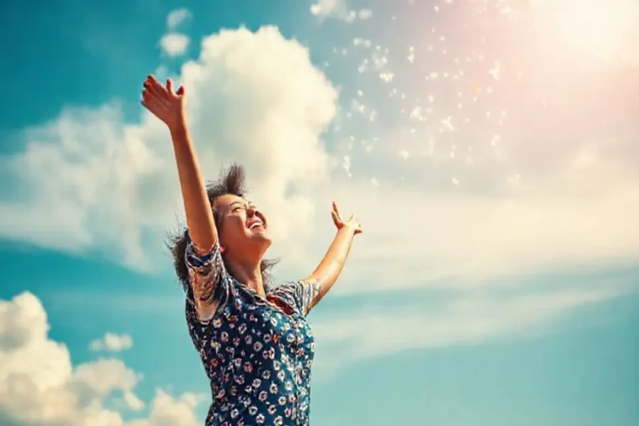 Mulher sorridente sonhando com um futuro financeiro promissor.