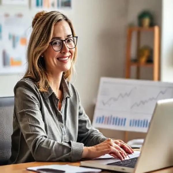 Mulher trabalhando em sua mesa com gráficos financeiros.