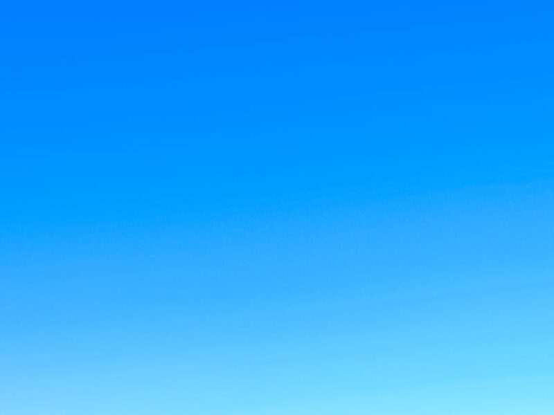 A serene view of a vibrant clear blue sky with a subtle gradient, perfect for backgrounds.