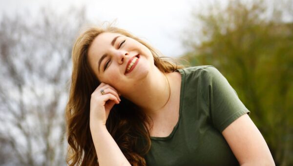 A carefree woman enjoying a sunny day outdoors, expressing pure happiness and relaxation.