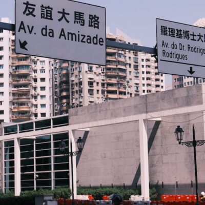 Street view in Macau with bilingual road signs and urban architecture.