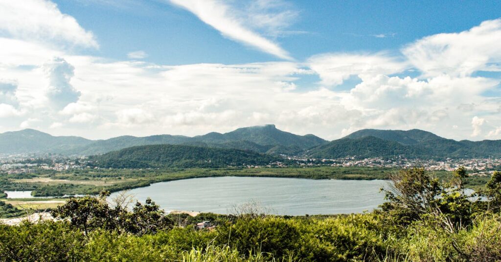 Breathtaking view of Rio de Janeiro's lush hills and serene lake under a vibrant summer sky.