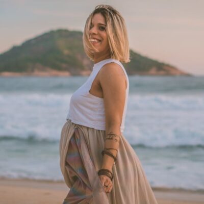 Expecting mother enjoying a serene walk on the beach at sunrise.