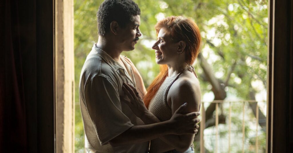 A loving couple sharing a tender moment by a doorway with natural light flowing in. Captured in Buenos Aires.
