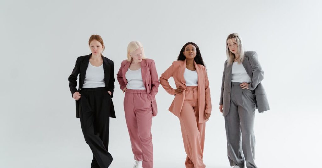 Four women posing confidently in colorful business suits against a white studio background.