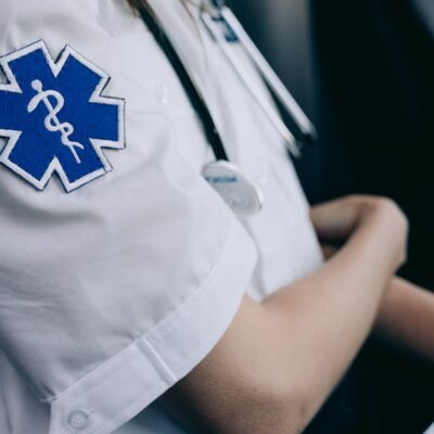 Paramedics in uniform work with medical charts inside an ambulance.