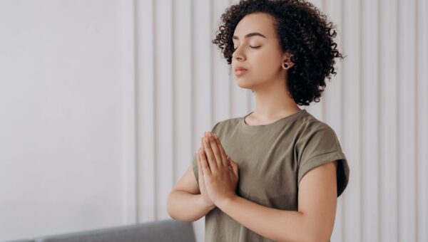 Young woman meditating indoors, practicing mindfulness and relaxation. Peaceful and serene atmosphere.