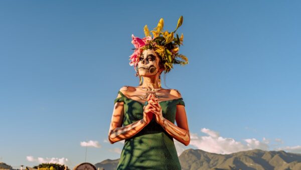 A woman in traditional Day of the Dead makeup and flower crown in Oaxaca, Mexico.