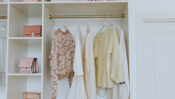 Neat closet showcasing white and pink clothes and accessories for a chic, clean look.