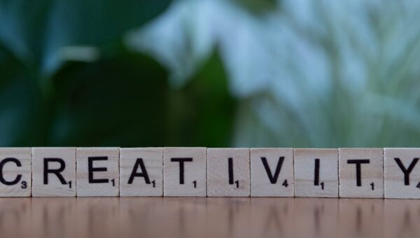 Scrabble tiles spelling 'CREATIVITY' with a blurred green background.