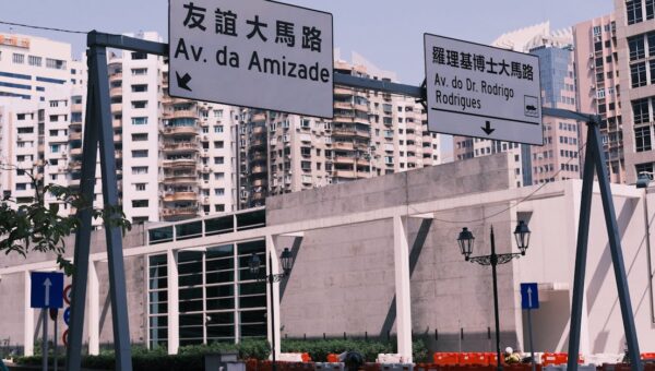 Street view in Macau with bilingual road signs and urban architecture.