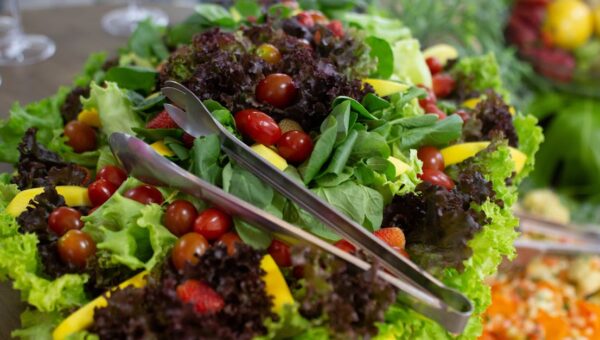 Vibrant mixed green salad with cherry tomatoes and fresh vegetables, perfect for a healthy meal.