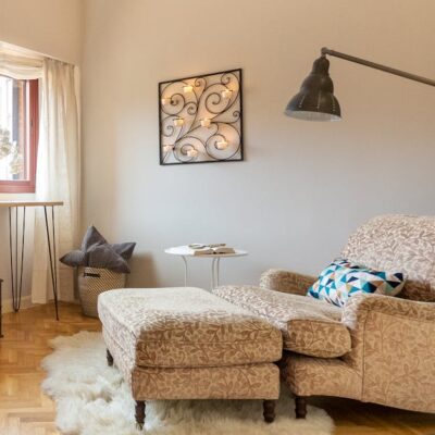 Luxurious living room corner in Madrid featuring a plush lounge chair, rug, and modern decor.