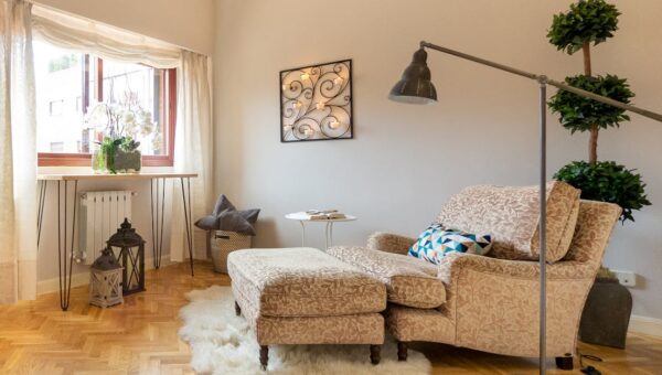Luxurious living room corner in Madrid featuring a plush lounge chair, rug, and modern decor.