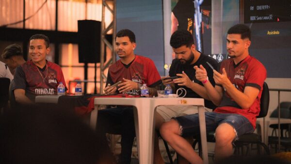 A group of e-sports players participating in a gaming event, focused on smartphone gameplay.