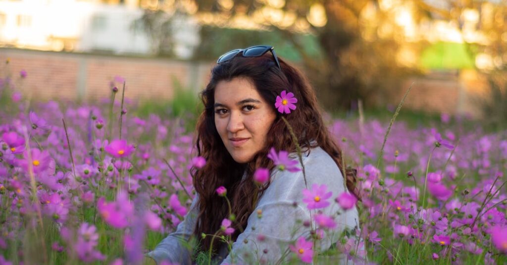 A serene portrait of a woman sitting in a field of pink flowers in Lerma, Mexico, at sunset.
