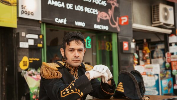 A man in a naval uniform poses at an outdoor cafe in Buenos Aires, Argentina.