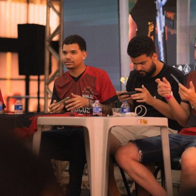 A group of e-sports players participating in a gaming event, focused on smartphone gameplay.