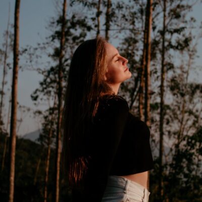 Portrait of a woman enjoying nature and freedom in a forest setting.