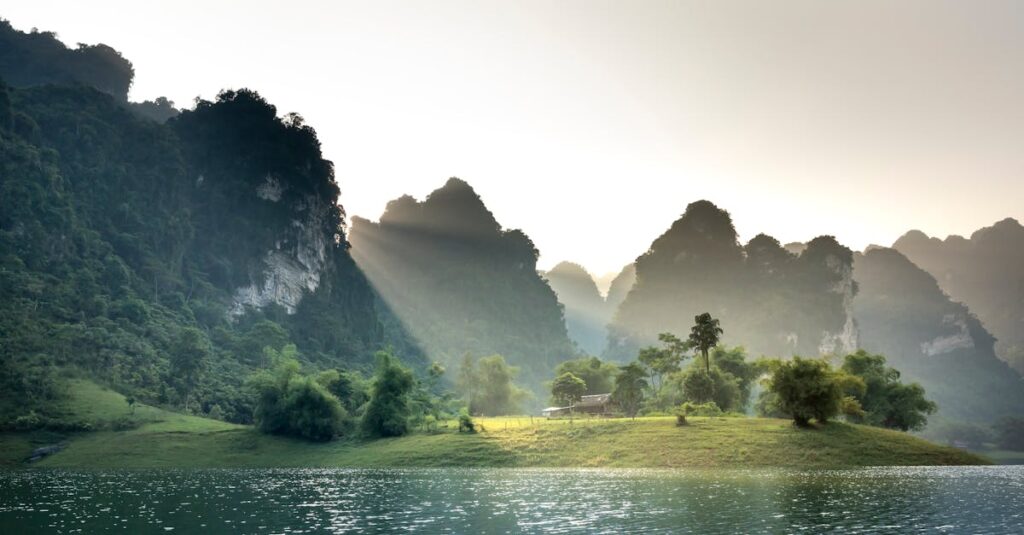 Peaceful scene of sunlit mountains and a tranquil lake in Tuyen Quang, Vietnam.
