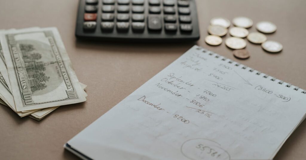 Desk setup showing calculator, cash, coins, and financial notes for budgeting.