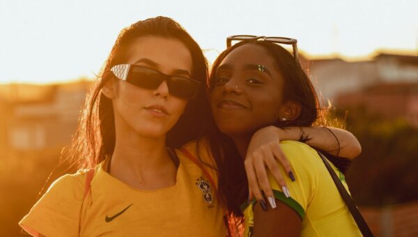 Two fashionable women in sunglasses enjoying a vibrant outdoor sunset.