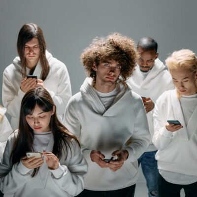 A group of diverse young adults focused on smartphones, symbolizing modern technology and digital connection.