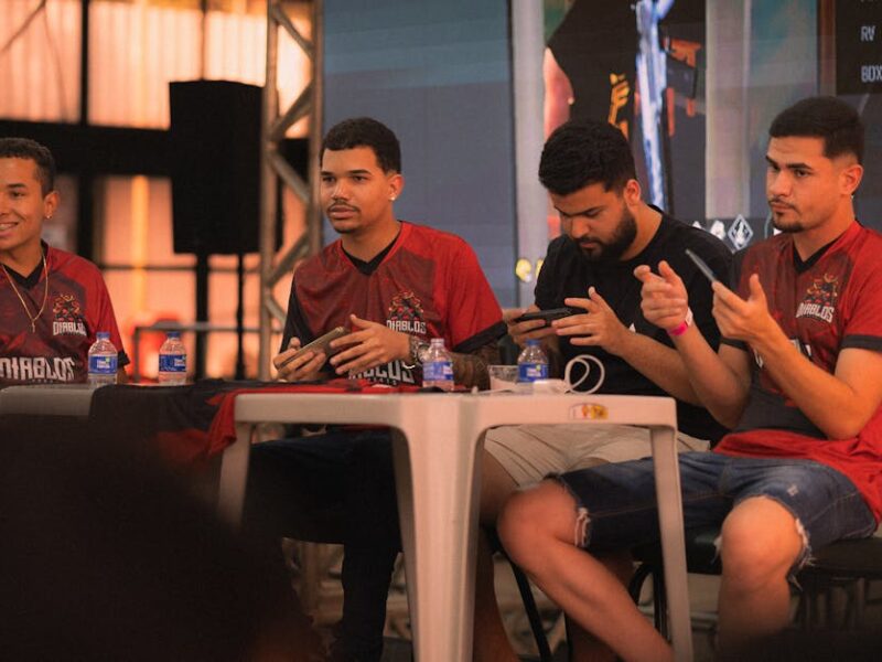 A group of e-sports players participating in a gaming event, focused on smartphone gameplay.