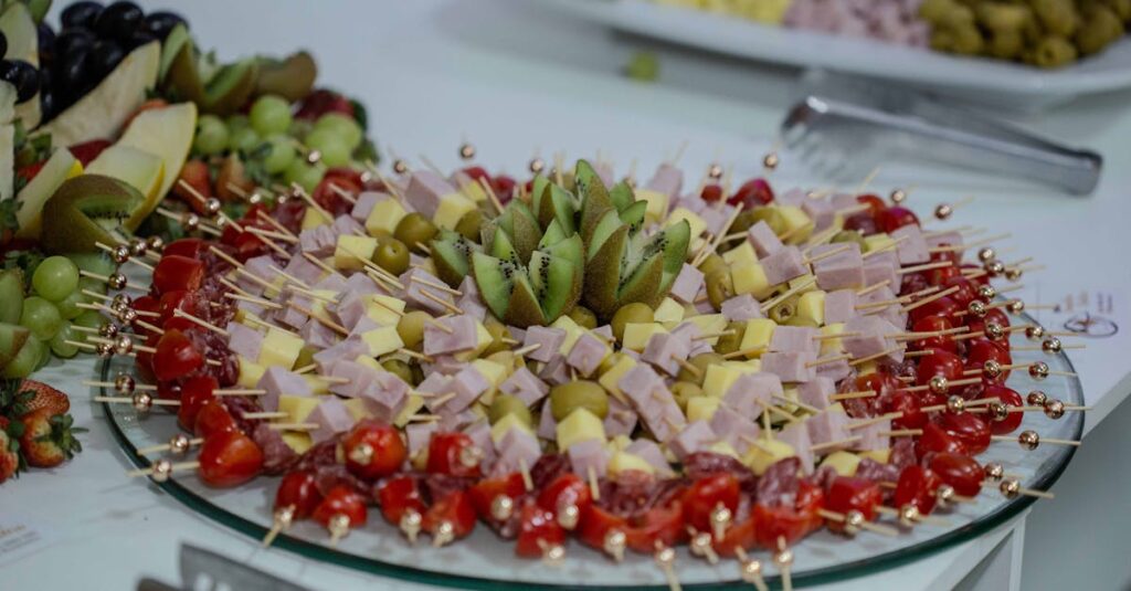 Vibrant platter of fruit and cheese skewers with kiwi, olives, and tomatoes, perfect for snacking.