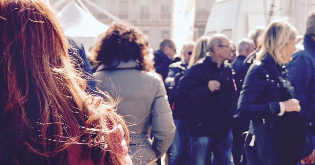A lively group of people gathers in an outdoor setting during daytime.