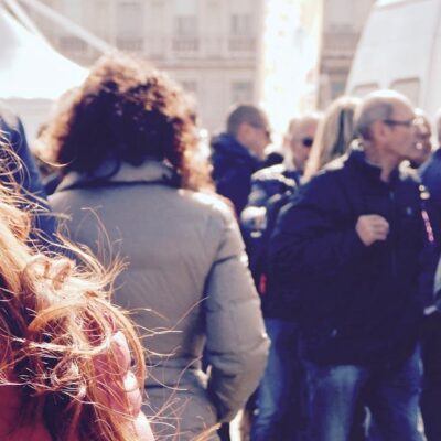 A lively group of people gathers in an outdoor setting during daytime.