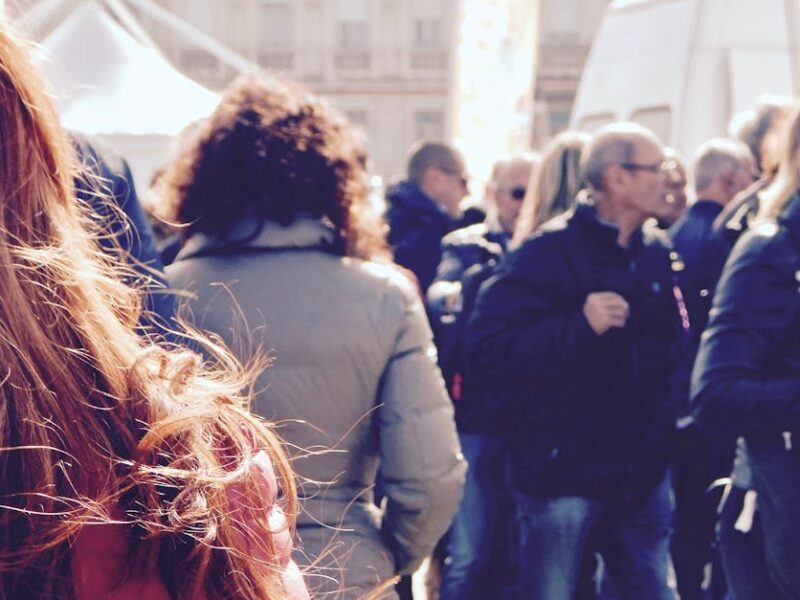 A lively group of people gathers in an outdoor setting during daytime.