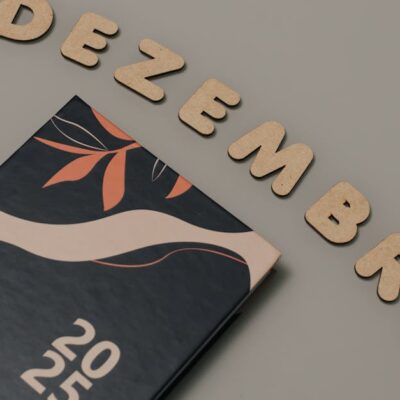 Stylish 2025 planner with 'Dezembro' wooden letters on a neutral background.