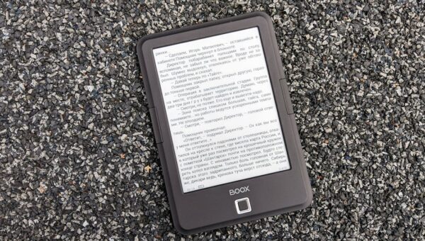 Digital BOOX e-book reader placed on a textured gravel surface, offering a tech contrast.