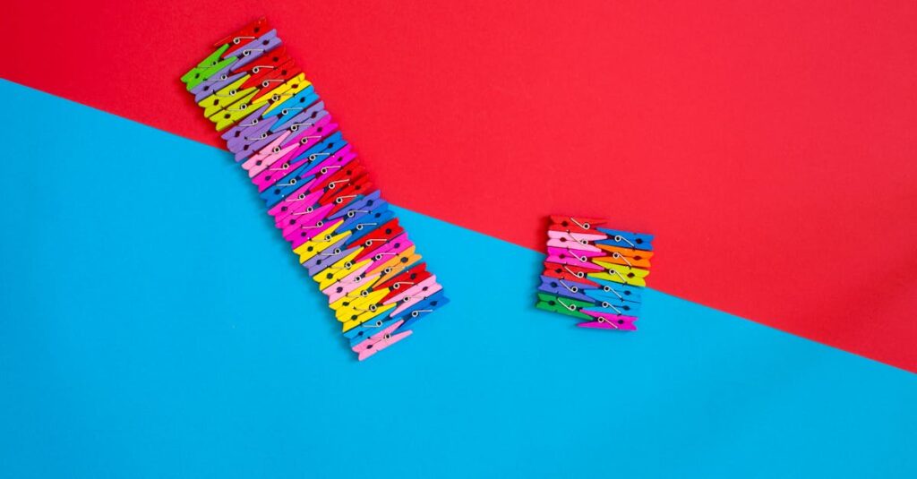 Multicolored clothespins arranged creatively on a red and blue geometric background.