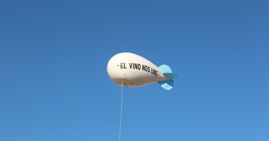 A white balloon with 'El Vino Nos Une' phrase floats against a clear blue sky.