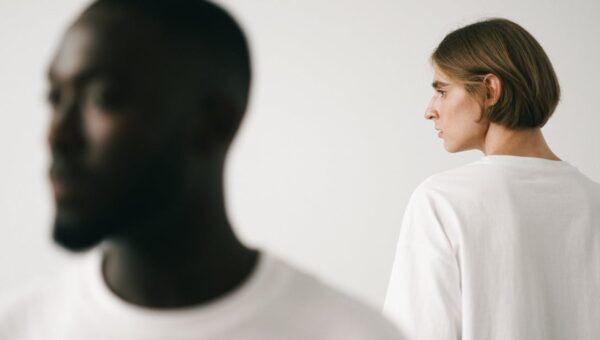Stylish studio portrait of two models, emphasizing minimalist fashion in white t-shirts.