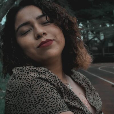 Portrait of a serene woman with curly hair, enjoying autumn in a Huatusco park.