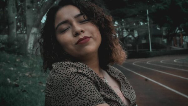 Portrait of a serene woman with curly hair, enjoying autumn in a Huatusco park.