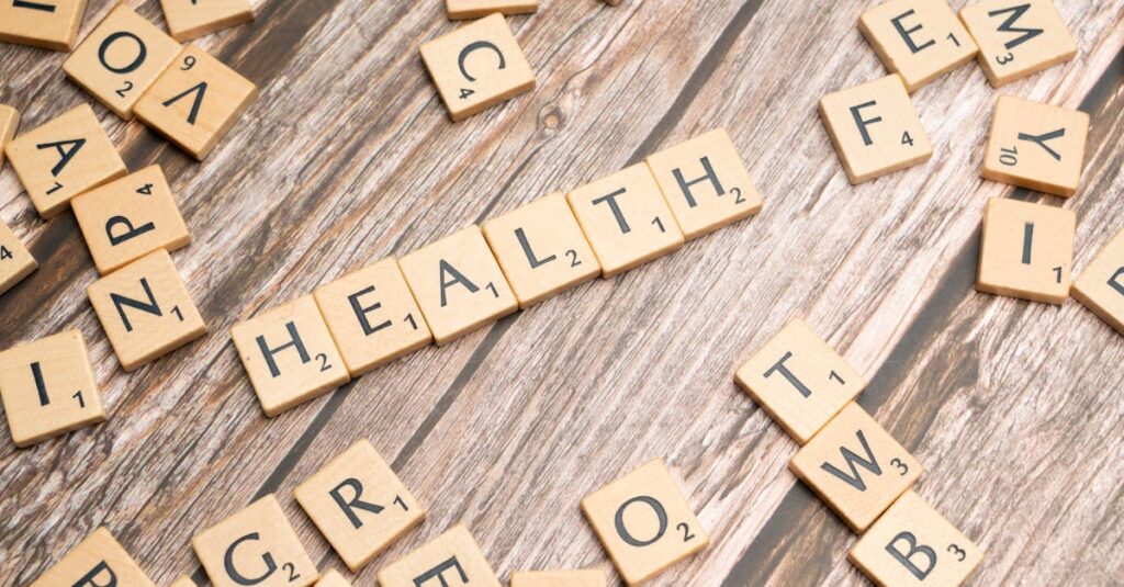 Scrabble tiles spelling 'HEALTH' on wooden surface, symbolizing wellness.