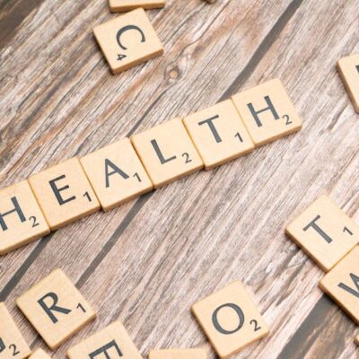 Scrabble tiles spelling 'HEALTH' on wooden surface, symbolizing wellness.