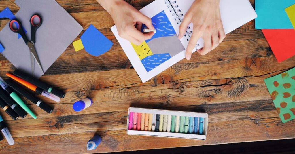 A vibrant arts and crafts setup with colorful papers and pastel colors on a wooden table.