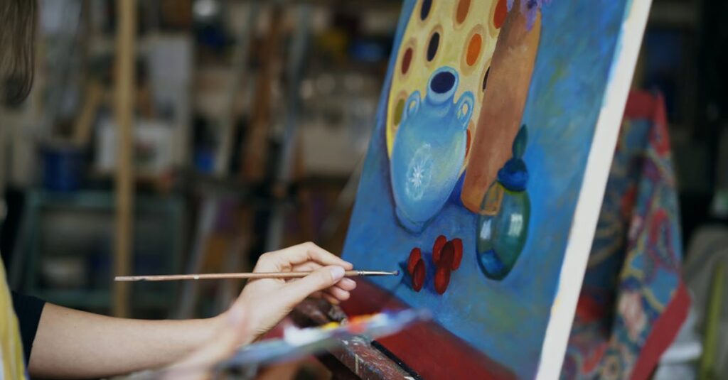 Close up of artist's hand painting a still life on canvas in a studio environment.