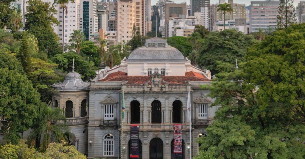 Elegant view of the Palace of Liberty surrounded by lush trees and modern skyline in Belo Horizonte, Brazil.