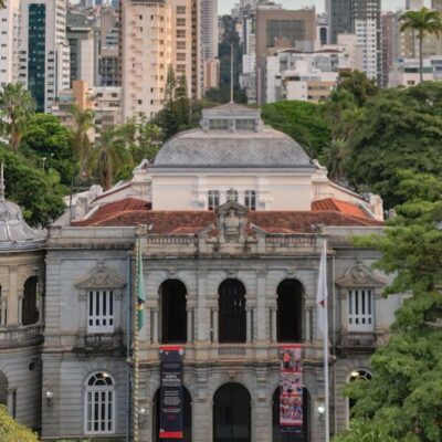Elegant view of the Palace of Liberty surrounded by lush trees and modern skyline in Belo Horizonte, Brazil.
