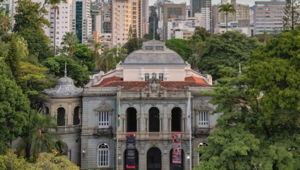 Elegant view of the Palace of Liberty surrounded by lush trees and modern skyline in Belo Horizonte, Brazil.