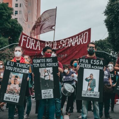 Protest in Rio de Janeiro with people holding banners demanding justice and equality.
