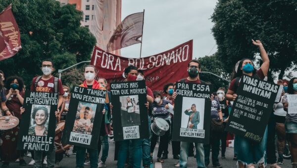 Protest in Rio de Janeiro with people holding banners demanding justice and equality.
